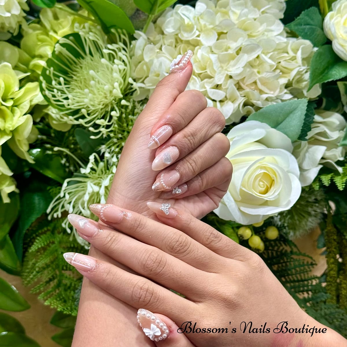 Soft nude ombré nails with pearls and silver accents at Blossom's Nails Boutique