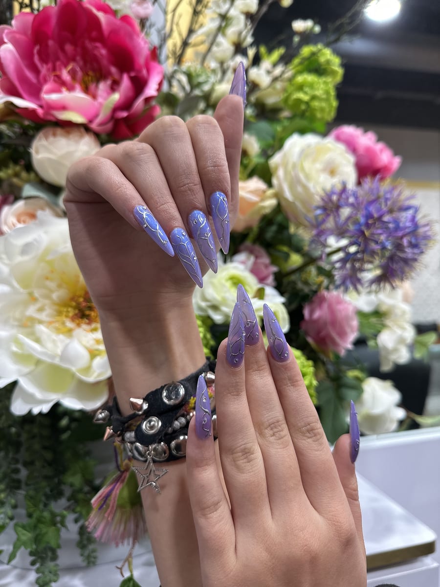Lavender stiletto nails with silver chrome line art at Blossom's Nails Boutique
