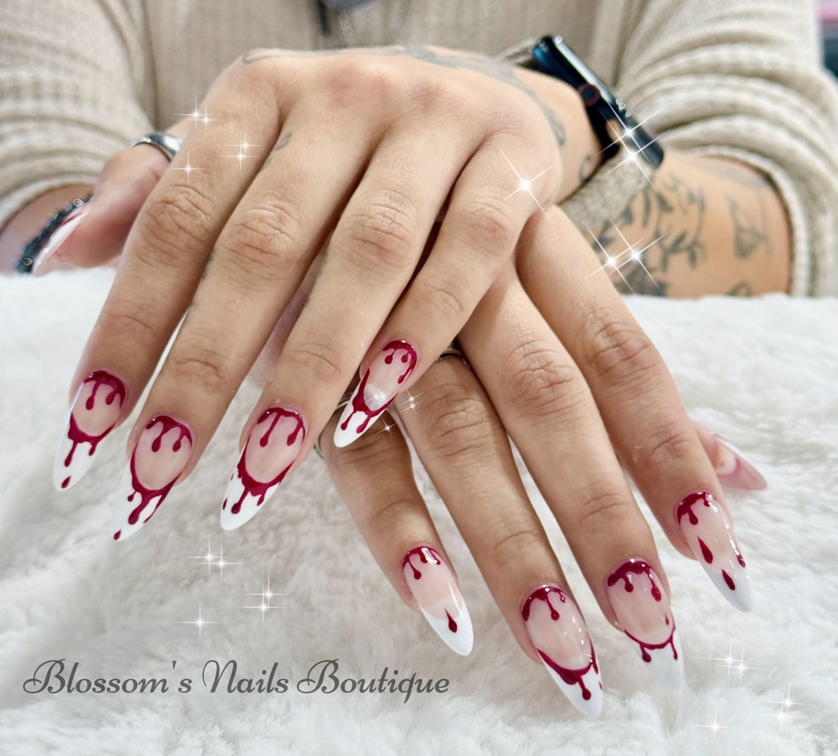 White French tip nails with a red drip design at Blossom's Nails Boutique